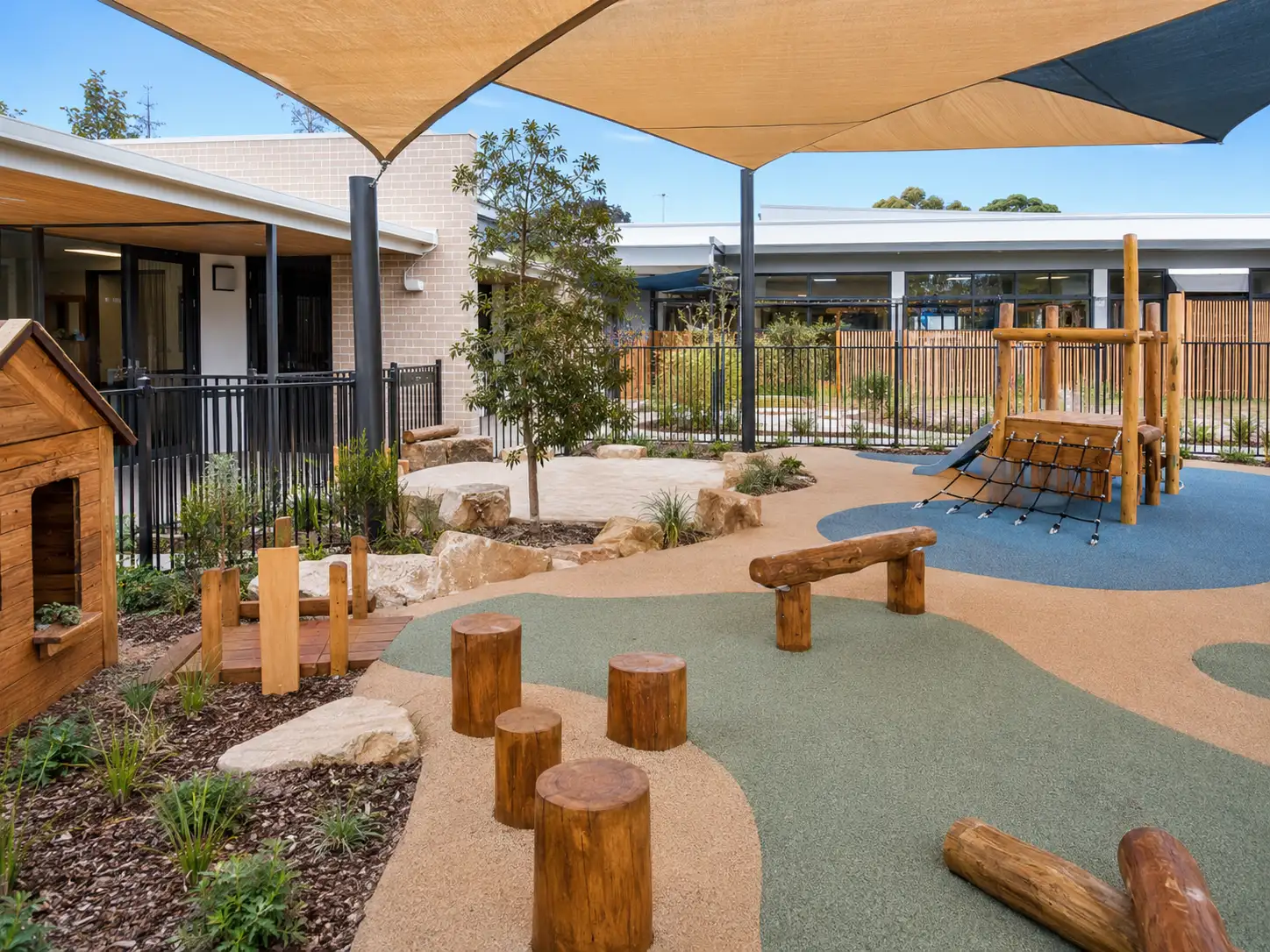 Childcare centre outdoor play area Sydney with rubber safety surfacing, shade structures and child safe fencing